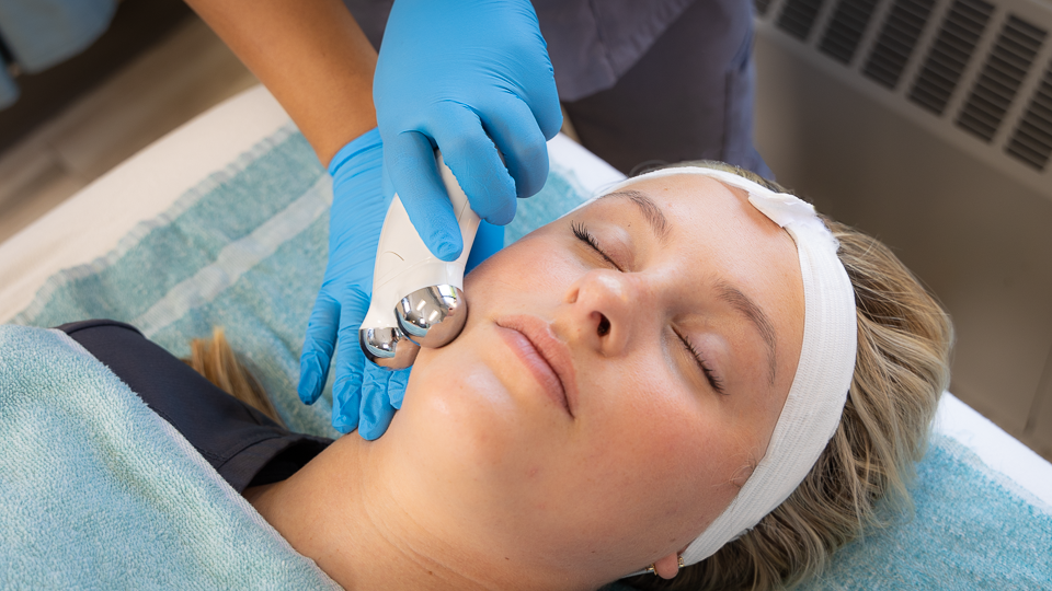 Student applying facial treatment to a spa visitor