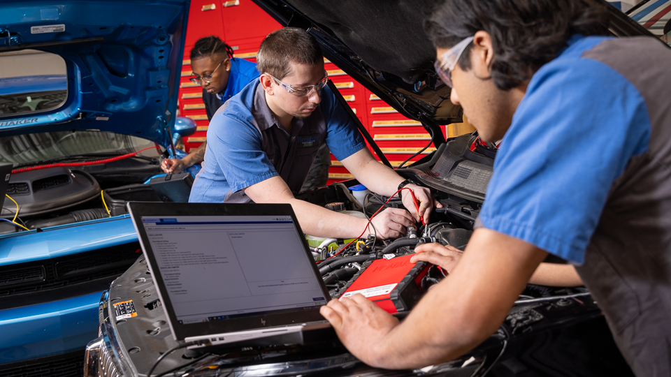 students working on car