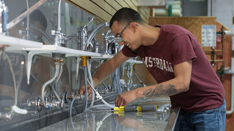 man testing faucet